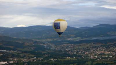 Der Heißluftballon des Deutsch-Französischen Jugendwerks von einem anderen Ballon aus fotografiert. Der Ballon befindet sich in der Bildmitte, im HIntergrund die Landschaft des Zentralmassivs.