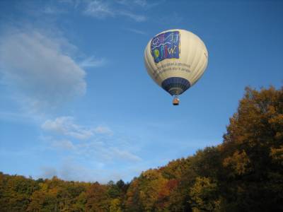 Der Heißluftballon des DFJW über dem herbstlich gefärbten Wald.